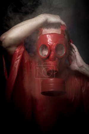 Photo for Cloak, A man in a gas mask over  the smoke - Royalty Free Image