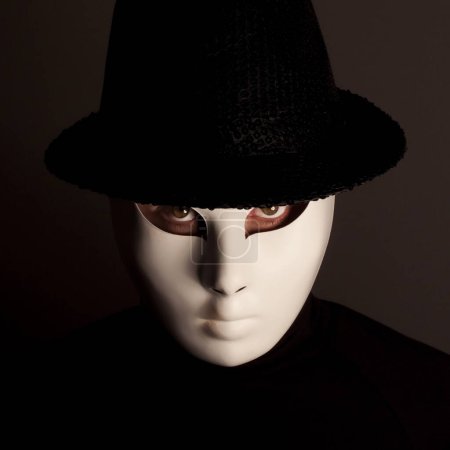 Téléchargez les photos : Homme en masque noir avec chapeau noir. - en image libre de droit