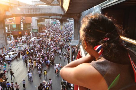 Foto de BANGKOK-JANUARY 13: Unidentified woman looking to Thai protesters on RAMA 1 street on Jan 13, 2014 in Bangkok, Thailand. - Imagen libre de derechos
