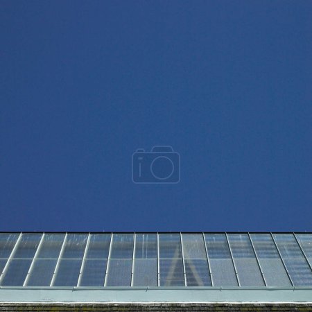 Téléchargez les photos : Bâtiment avec toit en verre sur fond bleu ciel - en image libre de droit
