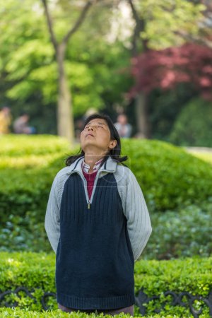 Téléchargez les photos : Une femme exerçant la méditation dans le parc, shanghai, Chine - en image libre de droit