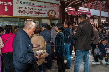 Téléchargez les photos : Personnes mangeant dim sum Shanghai style boulettes de porc à la vapeur chi - en image libre de droit