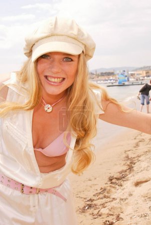 Téléchargez les photos : France, Cannes. Gry Bay posant sur la plage et portant une tenue en soie blanche. - en image libre de droit