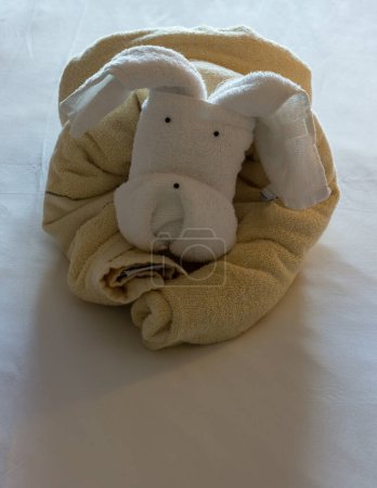 Foto de Ciervo de cabra o perro en forma de toallas dobladas en la cama - Imagen libre de derechos