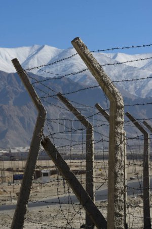 Photo for Barbed wire fence in winter with snow mountain background - Royalty Free Image