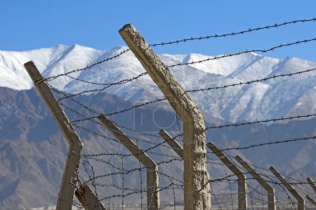 Photo for Barbed wire fence in winter with snow mountain background - Royalty Free Image