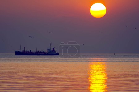Photo for Bulk-carrier ship at sunset in the sea - Royalty Free Image