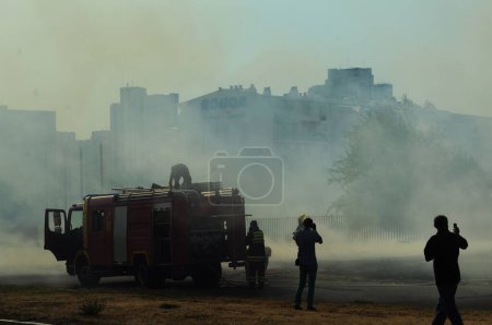 Foto de Bomberos en el trabajo tratando de controlar el fuego en el campo de combustión - Imagen libre de derechos