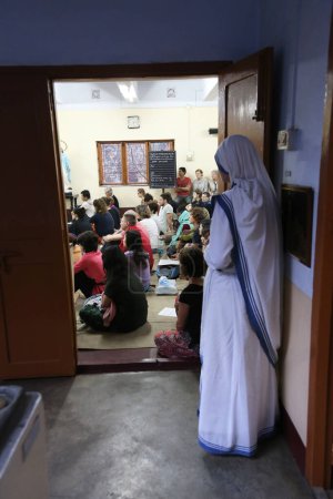 Foto de Hermanas de las Misioneras de la Caridad de la Madre Teresa y voluntarias de todo el mundo en la Misa en la capilla de la Casa Madre, Calcuta - Imagen libre de derechos