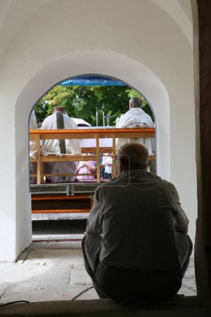 Téléchargez les photos : Homme assis à la porte de l'église - en image libre de droit