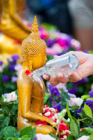 Foto de Persona que vierte un agua en la estatua de Buda - Imagen libre de derechos