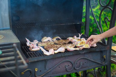 Photo for "Grilled steak and chiken cooking on an open barbecue" - Royalty Free Image
