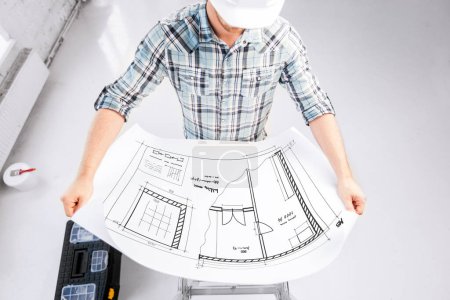 Photo for Male architect in helmet with blueprint - Royalty Free Image