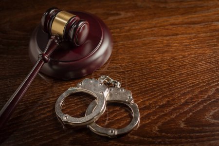 Photo for Gavel and Pair of Handcuffs on Table - Royalty Free Image