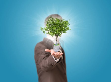 Photo for World map and man hold bulb with tree - Royalty Free Image