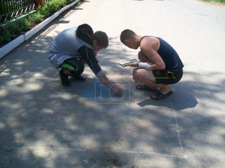 Téléchargez les photos : Les enfants tirent sur l'asphalte - en image libre de droit