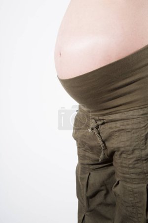 Téléchargez les photos : Femme enceinte avec pantalon vert - en image libre de droit