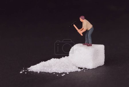 Foto de "Trabajador en miniatura trabajando en un cubo de azúcar
" - Imagen libre de derechos
