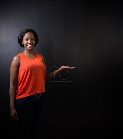Photo for "South African or African American woman teacher on chalk black board background" - Royalty Free Image