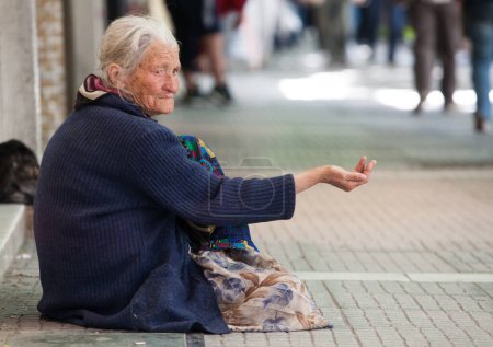 Téléchargez les photos : Femme mendiante dans la rue de la ville - en image libre de droit