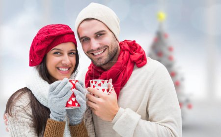 Téléchargez les photos : Image composite de couple d'hiver tenant des tasses - en image libre de droit