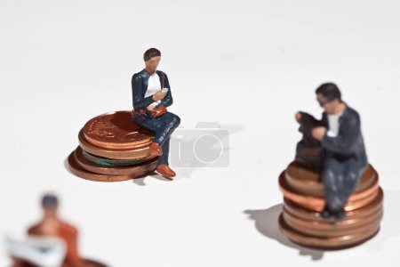 Foto de Personas en miniatura sentadas en monedas - Imagen libre de derechos