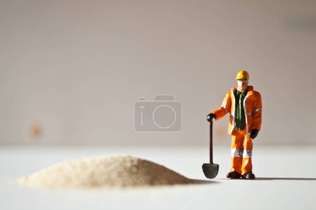 Photo for Miniature worker and a stack of sand - Royalty Free Image