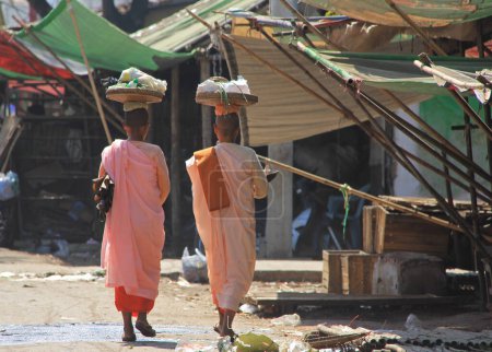 Téléchargez les photos : MANDALAY, MYANMAR - 24 NOVEMBRE 2015 : Des religieuses bouddhistes marchent dans une rue de la ville - en image libre de droit