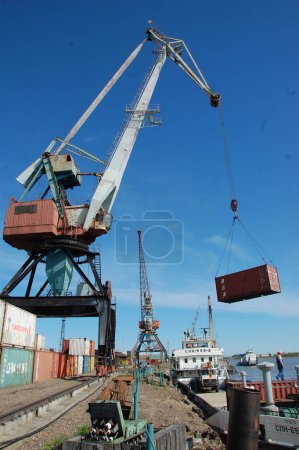 Photo for Dockside cargo crane with container at river port - Royalty Free Image