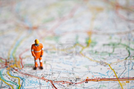 Photo for Miniature people in action on a roadmap - Royalty Free Image