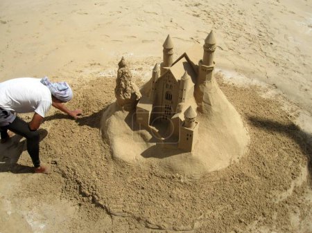 Téléchargez les photos : L'Homme joue avec un château de sable. - en image libre de droit