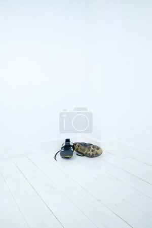 Foto de Botas de fútbol negro moldeadas en la esquina de una habitación vacía - Imagen libre de derechos