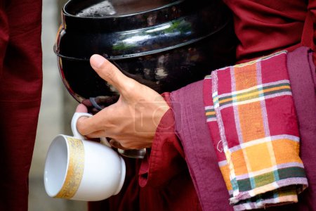 Téléchargez les photos : Détails colorés des mains de moine bouddhiste tenant un bol et une tasse - en image libre de droit