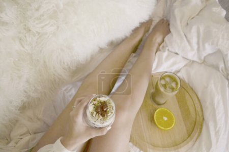 Foto de Young girl lying on the floor in a white room with a breakfast and a bowl of tea - Imagen libre de derechos