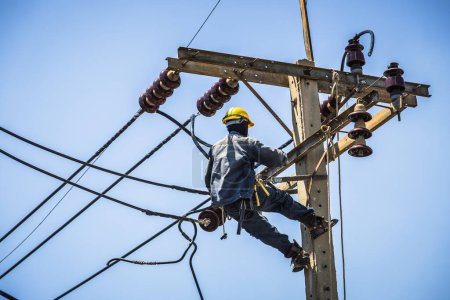 Téléchargez les photos : Électricien suspendu au poteau électrique - en image libre de droit