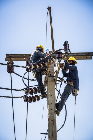 Photo for Electricians resting while working to replace the electrical insulator - Royalty Free Image