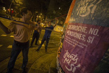 Foto de ESPAÑA, BARCELONA - 16 de septiembre de 2015: Un activista de la coalición independentista Junts pel Si Together for Yes levanta carteles en Barcelona la noche del 16 de septiembre de 2015. - Imagen libre de derechos