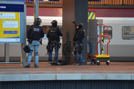 Téléchargez les photos : PAYS-BAS, Rotterdam : Des membres d'une unité spéciale de la police néerlandaise montent la garde près d'un train Thalys sur une plate-forme de la gare centrale de Rotterdam, le 18 septembre 2015 - en image libre de droit