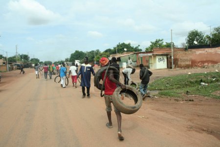 Foto de BURKINA FASO, Uagadugú: Manifestantes acarician neumáticos para ser quemados en Uagadugú, Burkina Faso, el 18 de septiembre de 2015. - Imagen libre de derechos