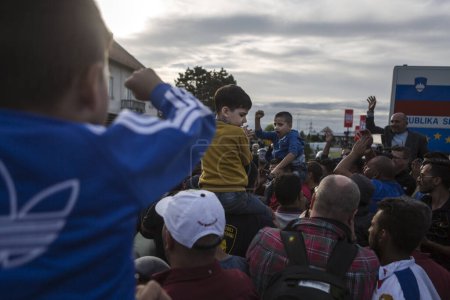 Téléchargez les photos : CROATIE, Harmica : Les réfugiés se tiennent debout et attendent sur un pont dans le village de Harmica, en Croatie, à la frontière de la Slovénie, le 19 septembre 2015, après que le gouvernement slovène a empêché les réfugiés d'entrer dans le pays avec la police anti-émeute. - en image libre de droit