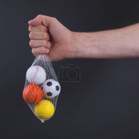 Téléchargez les photos : Main tenant de petites boules de jouet dans le sac - en image libre de droit