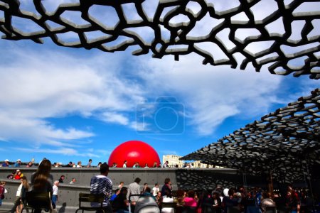 Foto de FRANCIA, Marsella: Esta foto tomada el 19 de septiembre de 2015 en Marsella, muestra una bola roja entre las columnas del Palais de Longchamp. El proyecto RedBall del artista neoyorquino Kurt Perschke se detuvo en Marsella entre el 19 y el 25 de septiembre de 2015. - Imagen libre de derechos