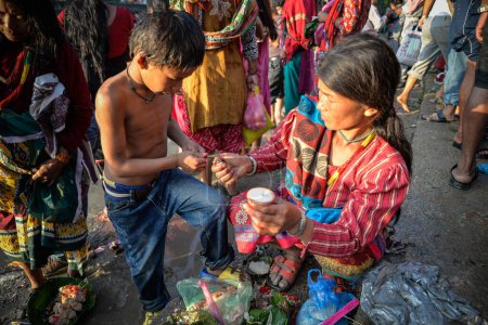 Téléchargez les photos : NEPAL, Nuwakot : Santosh Shrestha, un garçon de 10 ans originaire d'Okharpauwa, dans le district de Nuwakot, effectue un rituel religieux à Bagamti River Bank pendant la fête des pères, le 13 septembre 2015. - en image libre de droit
