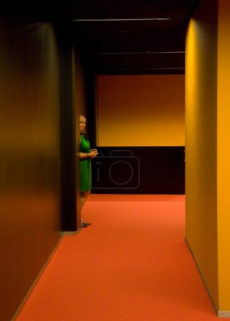 Téléchargez les photos : Intérieur de la chambre d'hôtel avec femme debout près de la porte - en image libre de droit