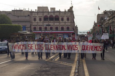Foto de México, Morelia: Cientos de personas marchan durante una manifestación que conmemora el primer aniversario de la desaparición de los 43 estudiantes de Ayotzinapa, en Morelia, México, 26 de septiembre de 2015 - Imagen libre de derechos