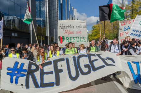 Téléchargez les photos : Belgique, Bruxelles : 15 000 manifestants portent des pancartes, des bannières et des t-shirts avec des slogans alors qu'ils assistent à un rassemblement de solidarité pour les migrants et les réfugiés dans les rues de Bruxelles, en Belgique, le 27 septembre 2015 - en image libre de droit