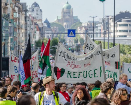 Photo for Belgium, Brussels: 15,000 Demonstrators carry placards, banners and t-shirts with slogans as they attend a solidarity rally for migrants and refugees in the streets of Brussels, Belgium on September 27, 2015 - Royalty Free Image