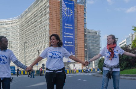 Téléchargez les photos : Belgique, Bruxelles : 15 000 manifestants portent des pancartes, des bannières et des t-shirts avec des slogans alors qu'ils assistent à un rassemblement de solidarité pour les migrants et les réfugiés dans les rues de Bruxelles, en Belgique, le 27 septembre 2015 - en image libre de droit