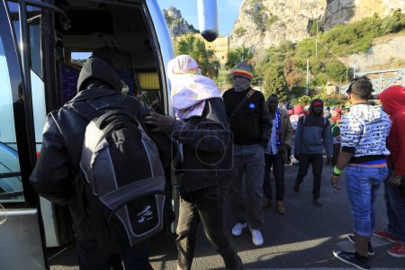 Téléchargez les photos : Italie, Vintimille : Evacuation du camp, les migrants montent dans l'autobus pour être accueillis dans le centre Croix-Rouge à Vintimille le 30 septembre 2015 - en image libre de droit