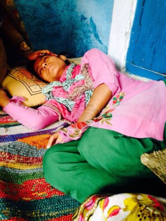 Photo for INDIA, Dadri: Shaista, age 16, daughter of Mohammad Ikhlaq who was killed by a mob over rumors that his family had been storing and consuming beef at their home is seen laying on the bed at her home in Dadri, Uttar Pradesh, India on October 1, 2015. - Royalty Free Image